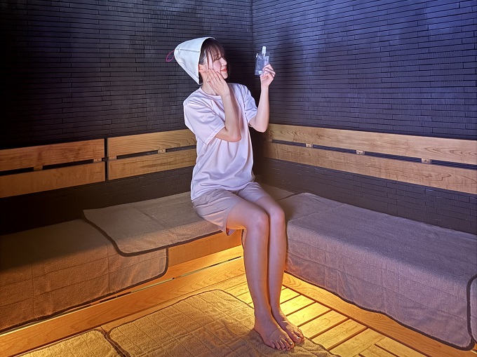 SPA＆SAUNA コリドーの湯のドライサウナで、サウナ用オールインワンジェルを試している女性